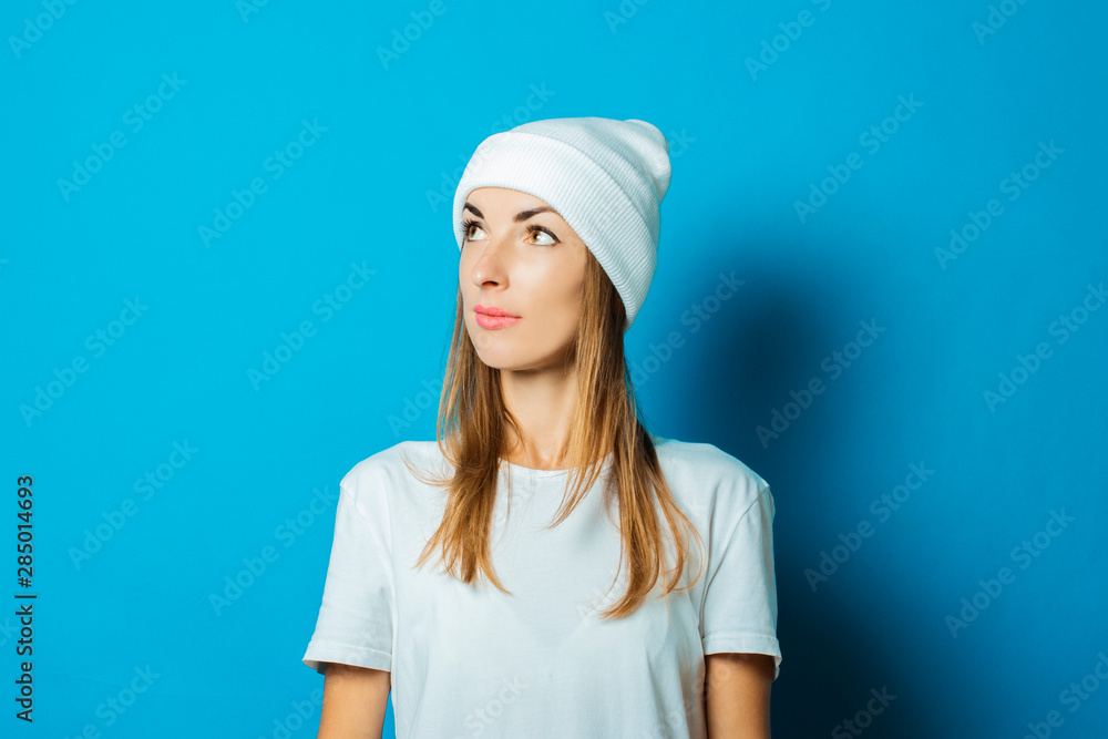 Young woman in white hat and t-shirt on a blue background Young woman in white hat and t-shirt on a blue background