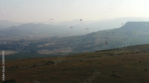Several paragliders is flying over the sunset valley with mountains at summer KOKTEBEL CRIMEA AUGUST 2019