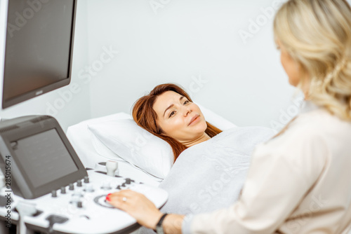 Woman examining her abdomen with ultrasound
