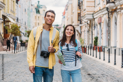 happy woman standing with cheerful bi-racial man on street © LIGHTFIELD STUDIOS