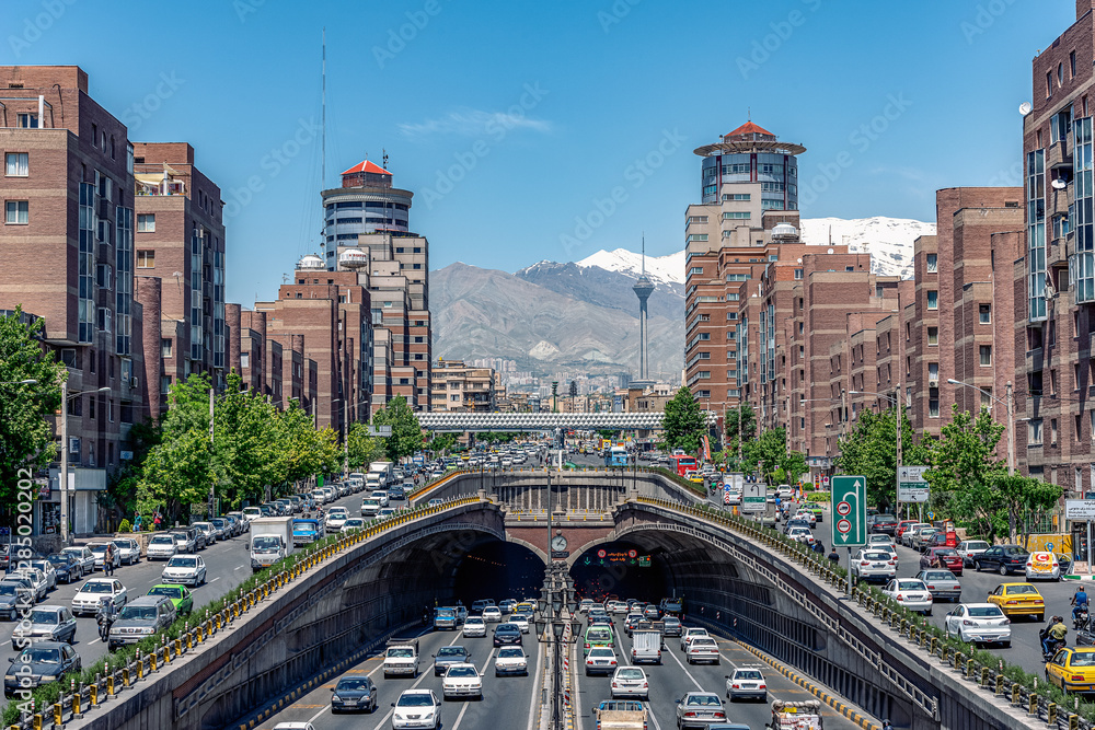 06/05/2019 Tehran,Iran,Famous view of Tehran,Flow of traffic inside, above and nearby round Tohid Tunnel with Milad Tower and Alborz Mountains in Background