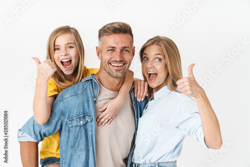Photo of excited caucasian family woman and man with little girl smiling and showing thumbs up