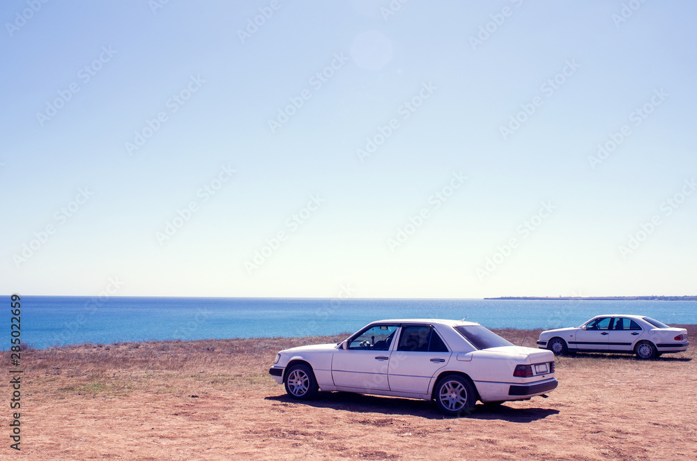 Cars stand on the beach in a clear summer afternoon, an impromptu Parking lot came to rest the owners of cars , copy space, instagram.