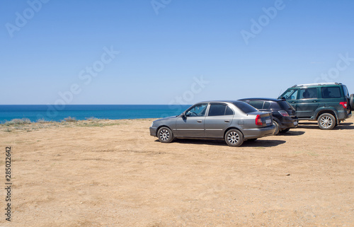 Cars stand on the beach in a clear summer afternoon  an impromptu Parking lot came to rest the owners of cars   copy space.