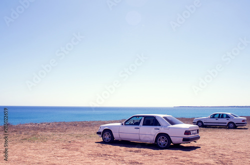 Cars stand on the beach in a clear summer afternoon, an impromptu Parking lot came to rest the owners of cars , copy space, instagram.