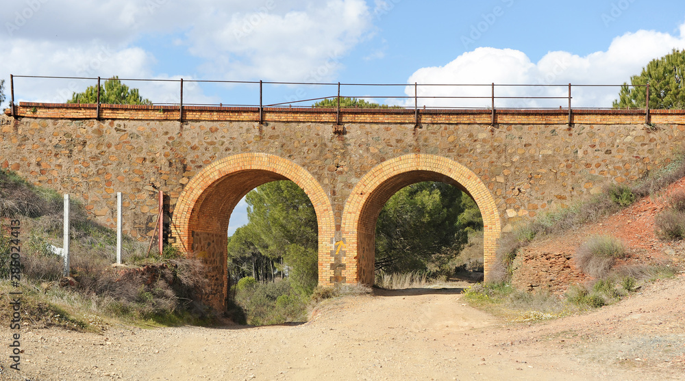  Sendero que pasa bajo arcos de piedra en la Vía Verde desde Valverde del Camino a Zalamea la Real, pueblos de la provincia de Huelva, Andalucía, España