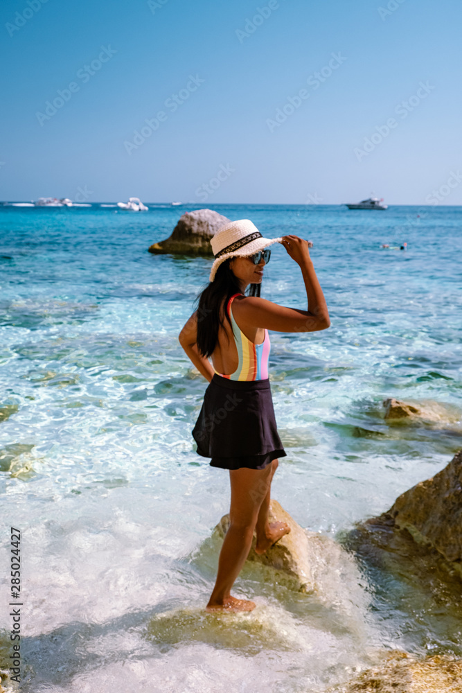 Φωτογραφία young woman on the beach with swimsuit, girl on the pebble beach on vacation Sar