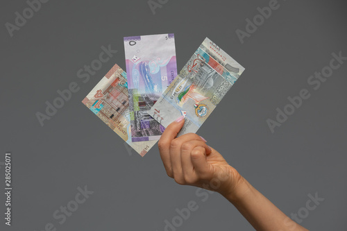Tableau sur toile Kuwaiti dinar banknote set in woman hand.