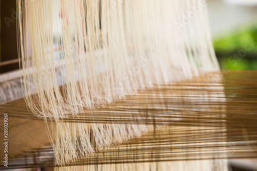 Woven silk, hand woven silk in Laos, Thailand, traditional weaving machines,Wooden hand held of loom for handmade weaving machine,handloom weaving ,Vintage concept