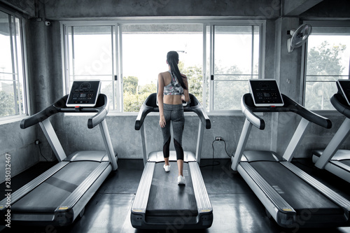 Asian women exercising on the running machine in the gym.