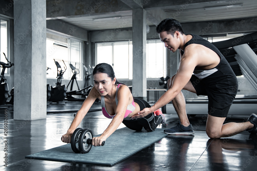 Obraz premium Sexy asian woman workout by ab wheel.