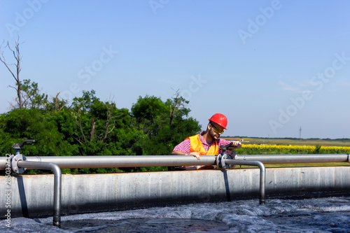 Fototapeta Naklejka Na Ścianę i Meble -  Worker inspecting valve during filtration
