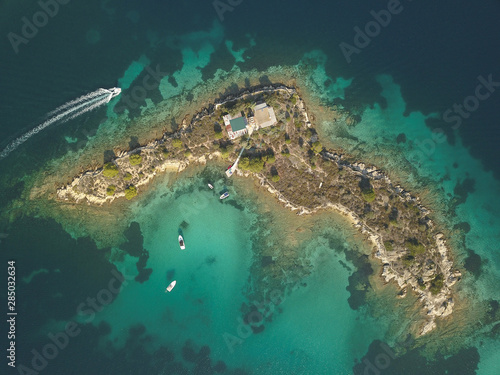 Halkidiki, Greece : boats and yachts moored near the private island in a secluded location on the Aegean sea. View from drone