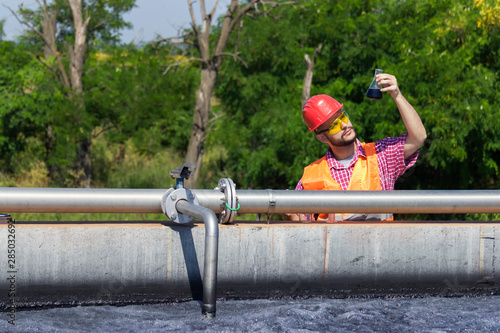 Fototapeta Naklejka Na Ścianę i Meble -  Worker inspecting water during filtration