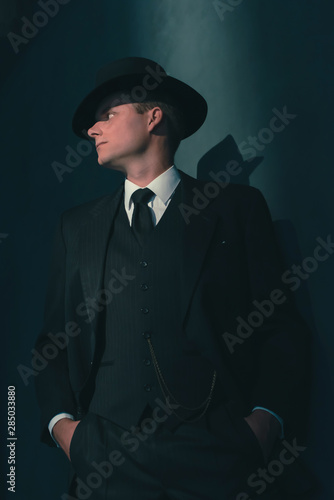 Retro man in hat wears suit and tie.