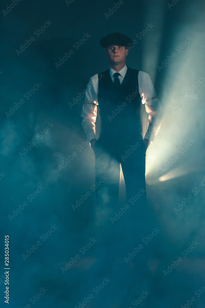 Retro businessman with cap standing in smoky room. Retro businessman with cap standing in smoky room.