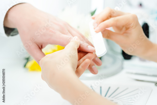 Murais de parede Woman filing fingernails of a man in nail parlor