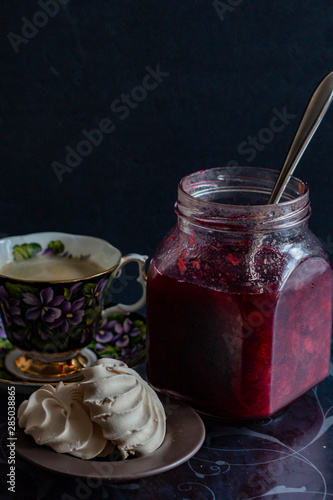 jam in a jar, tea and cake on a dark background