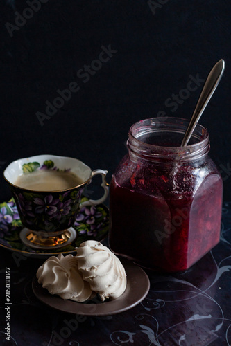 jam in a jar, tea and cake on a dark background