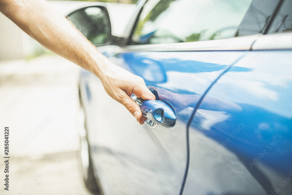 Close up of man opening door of blue vehicle. Close up of man opening door of blue vehicle.
