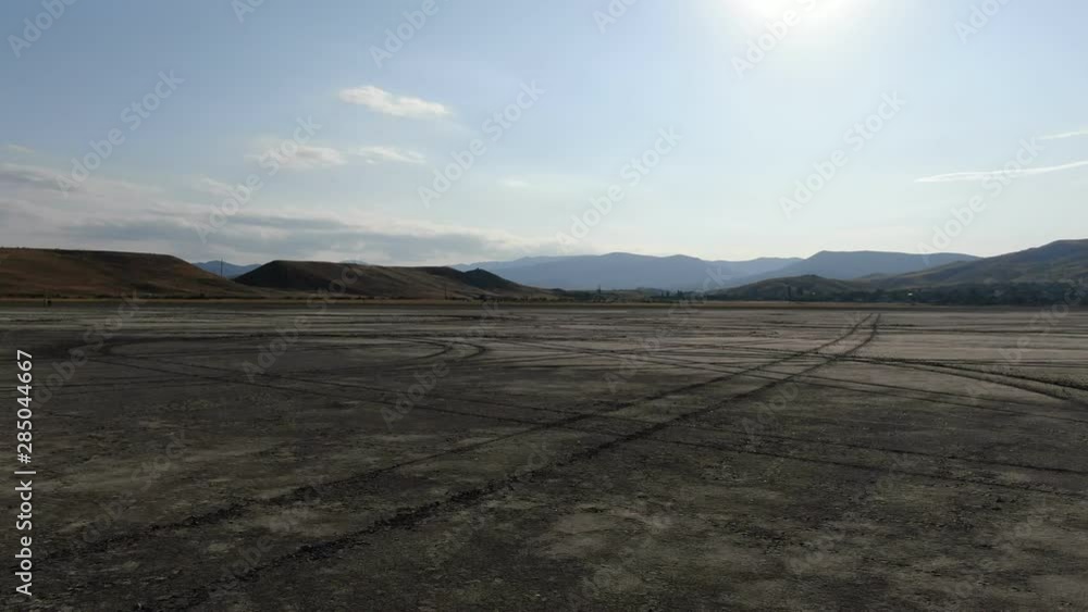 A view from the camera of a drone that circles above the bottom of a dried lake Traces of car wheels remained at the bottom of the lake CRIMEA AUGUST 2019 A view from the camera of a drone that circles above the bottom of a dried lake Traces of car wheels remained at the bottom of the lake CRIMEA AUGUST 2019