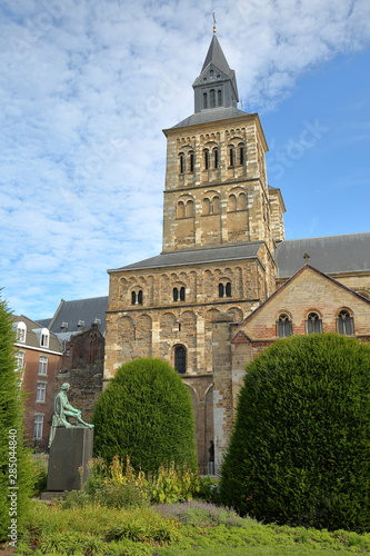 The basilica of Saint Servatius with the bronze statue of Hendrik van Veldeke (created by Charles Vos and unveiled in 1934) in the foreground, Maastricht, Netherlands photo