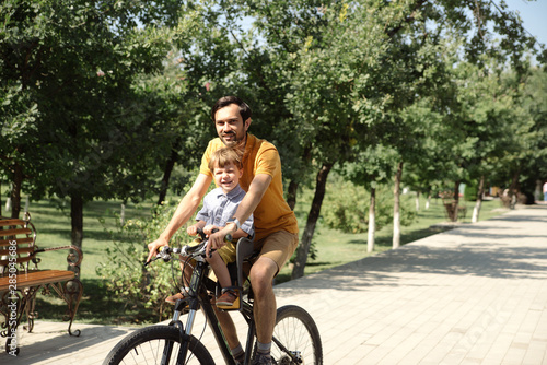 Bicycle ride of father and his son on baby seat © Alexander