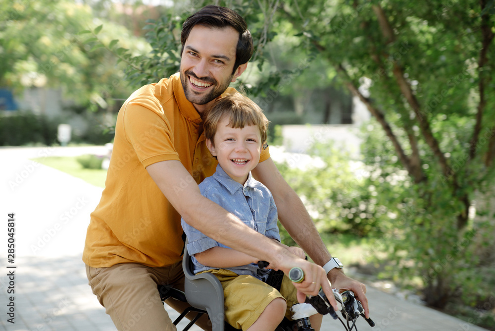 Bicycle ride of father and his son on baby seat Bicycle ride of father and his son on baby seat