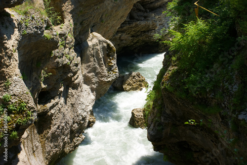 Fast mountain river in the summer. River rapids. Belaya river canyon in the foothills of the Caucasus. Raging water. Bubbling water.