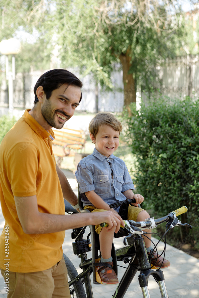 Bicycle ride of father and his son on baby seat Bicycle ride of father and his son on baby seat