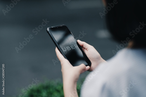 a girl using Uber Taxi service in Bangkok city,Thailand, August 19, 2019