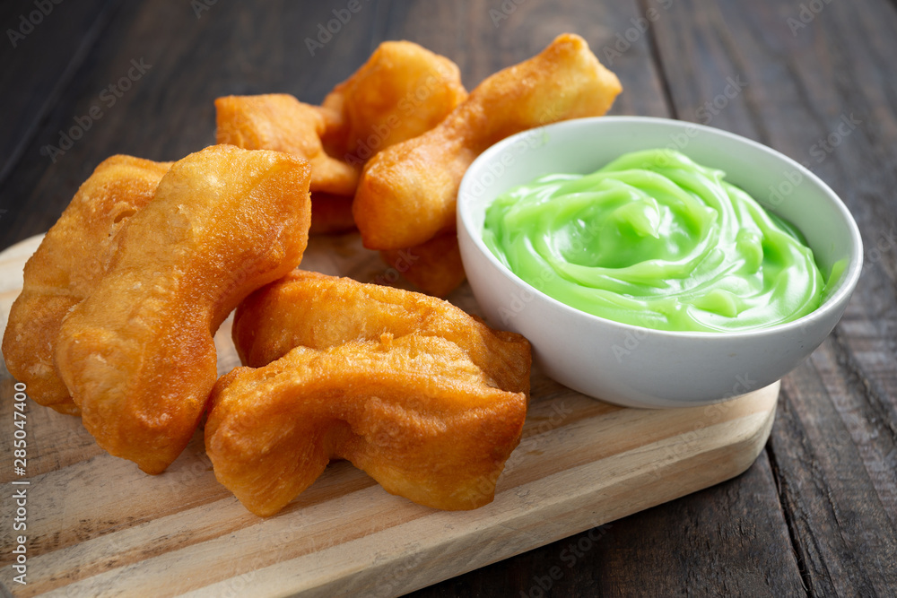 Chinese deep fried dough sticks and Pandan Custard on wood table.