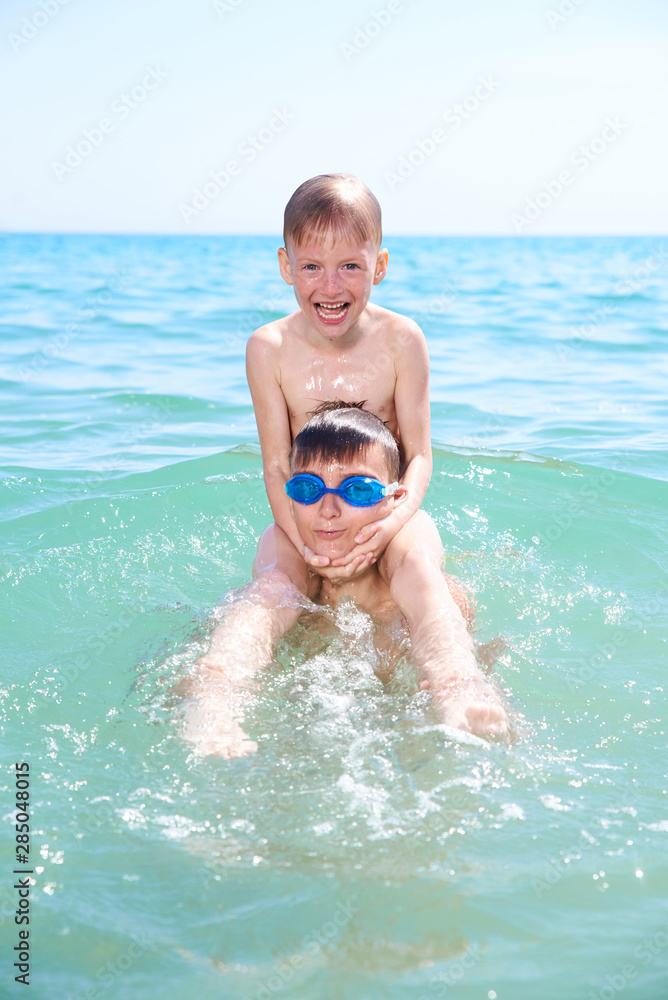 BROTHERS BOYS PLAY IN SEA WATER, SUMMER