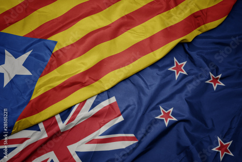 waving colorful flag of new zealand and national flag of catalonia.
