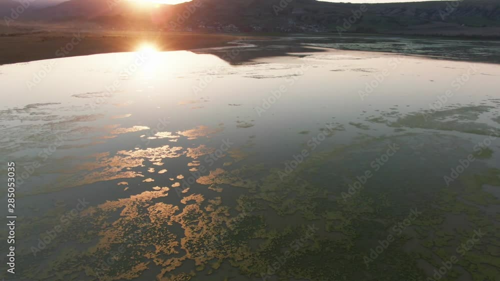 Flight at sunset over the surface of the lake. Evening sun sets. His last conspiracies are reflected in the water CRIMEA KOKTEBEL MARCH 2019 Flight at sunset over the surface of the lake. Evening sun sets. His last conspiracies are reflected in the water CRIMEA KOKTEBEL MARCH 2019