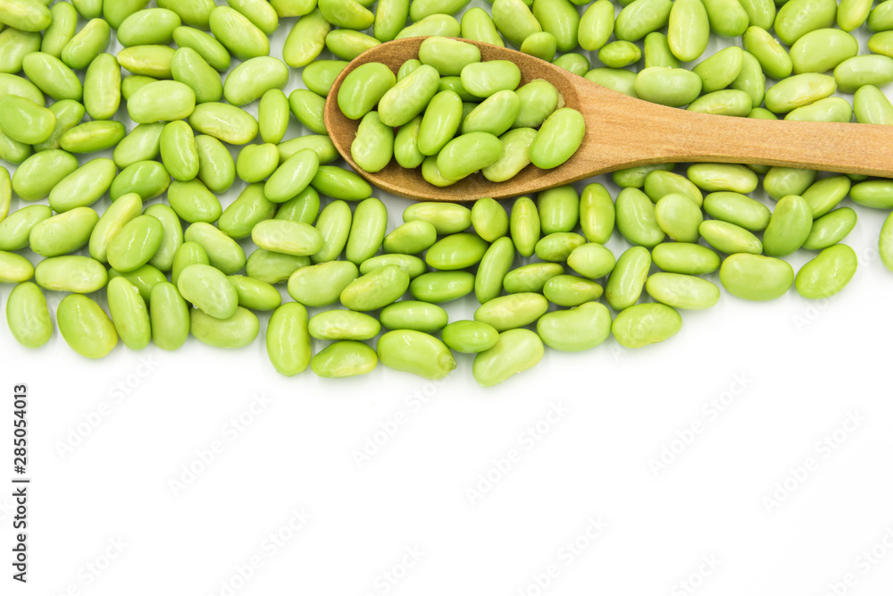 Dense green soybeans and wooden spoon top view Dense green soybeans and wooden spoon top view
