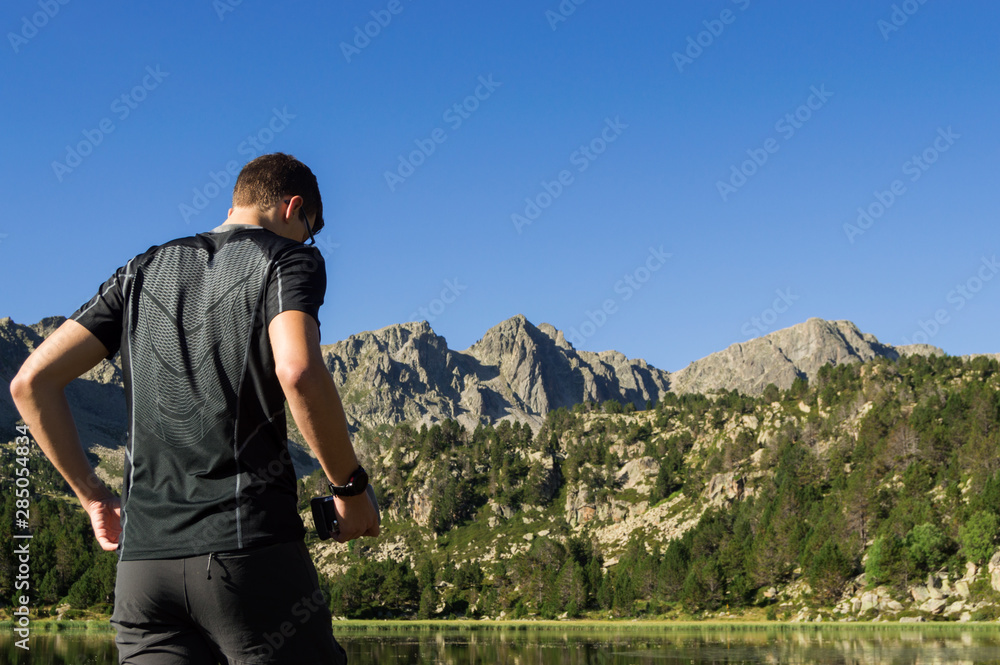 Young man doing sport next to a high mountain lake.