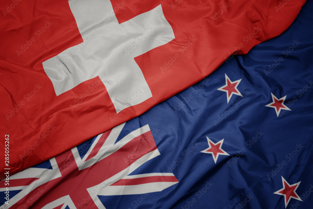 waving colorful flag of new zealand and national flag of switzerland. waving colorful flag of new zealand and national flag of switzerland.