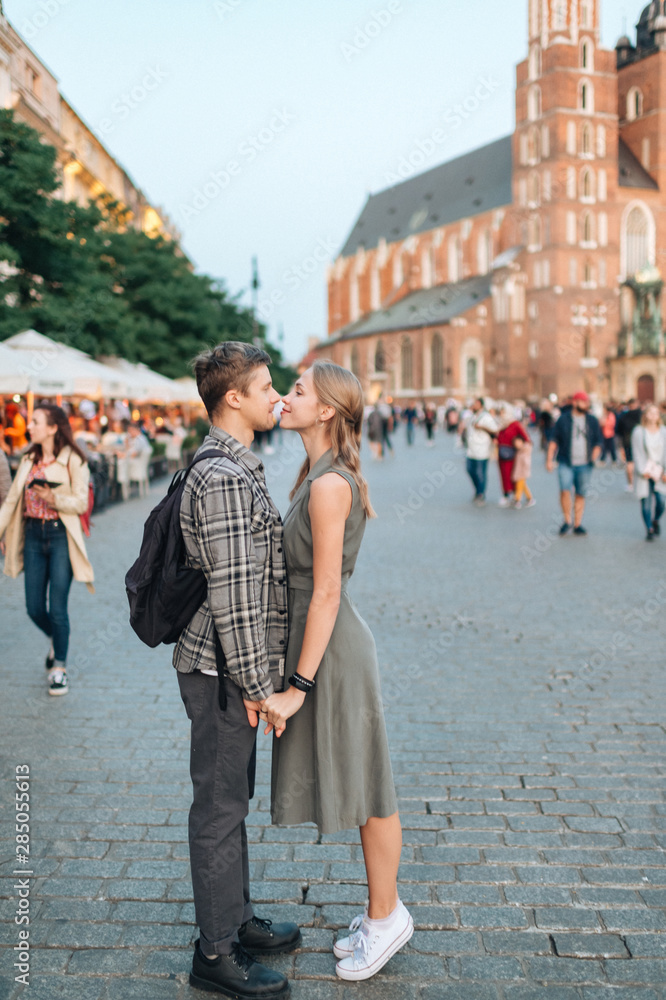 Fototapeta premium Young loving couple hugs at central square in Krakow (Cracow).