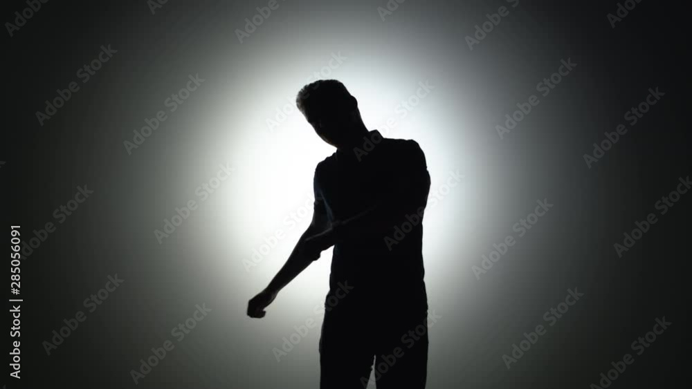 Silhouette of a carefree man dancing in the studio Silhouette of a carefree man dancing in the studio