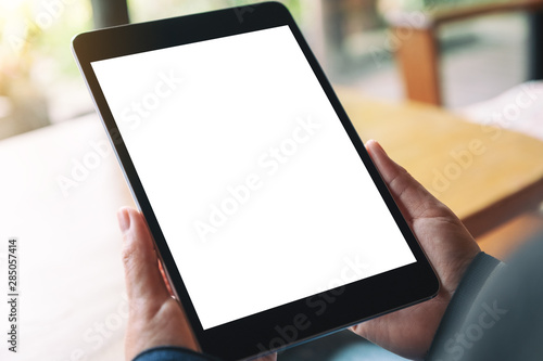 Mockup image of a woman holding black tablet pc with blank white desktop screen