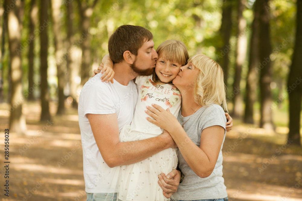 Three generation - grandmother, father, and little daughter. Family and people concept - happy excited smiling family at park outdoors Three generation - grandmother, father, and little daughter. Family and people concept - happy excited smiling family at park outdoors
