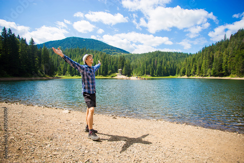 Free man with open arms near mountains lake. success. Travel and Freedom concept. Good life. © Svetlana