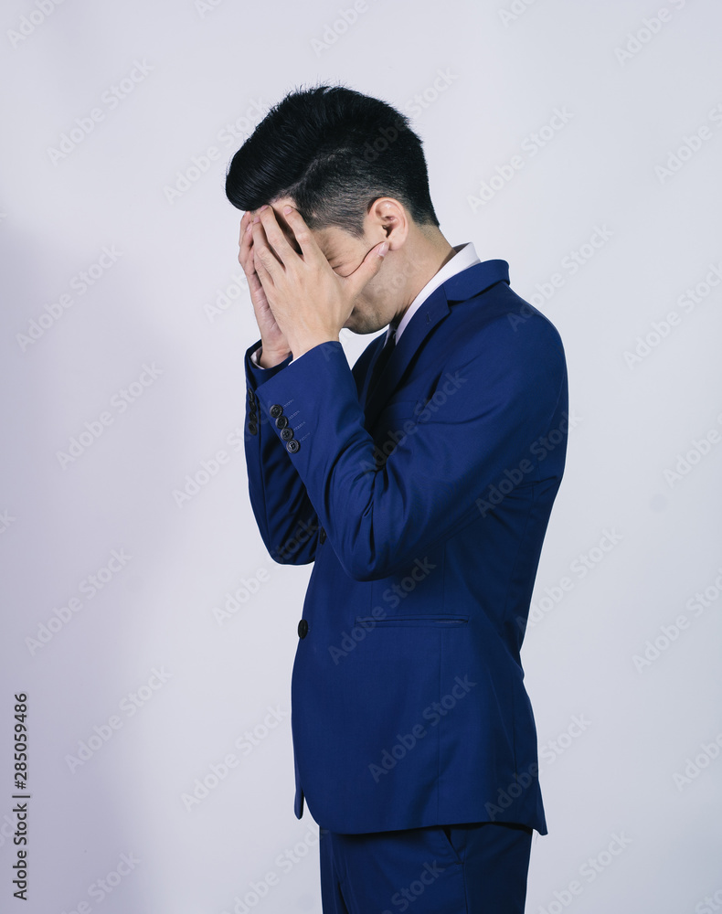Portrait handsome young asian .businessman wearing a blue suit feel stressfu isolated on grey background in studio. Asian man people. business success concept. Portrait handsome young asian .businessman wearing a blue suit feel stressfu isolated on grey background in studio. Asian man people. business success concept.