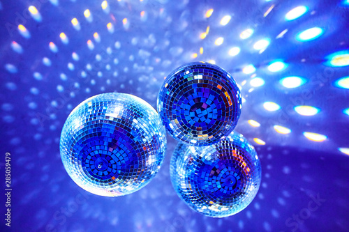 Disco balls with colorful bright rays , night party background photo.