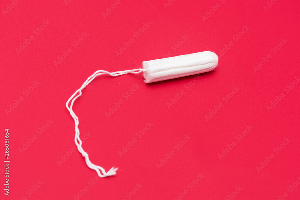 Tampon on a red background, close up, copy space, top view, menstrual period concept Tampon on a red background, close up, copy space, top view, menstrual period concept