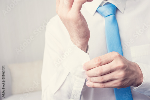 An office worker dressing up a shirt, the Manager is going to work, man's hands, cropped image, closeup