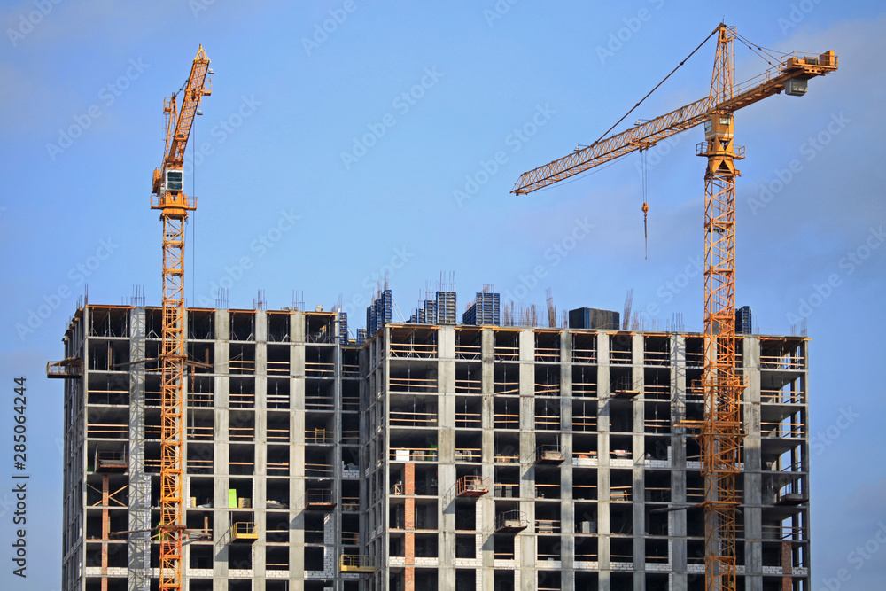 Building construction site with cranes. High-rise buildings and construction cranes. Buildings under construction. Property tax Building construction site with cranes. High-rise buildings and construction cranes. Buildings under construction. Property tax