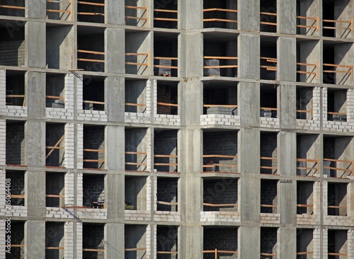 Monolithic construction of a multi-storey apartment building. Construction site. Construction in progress and concrete house frame. Property tax