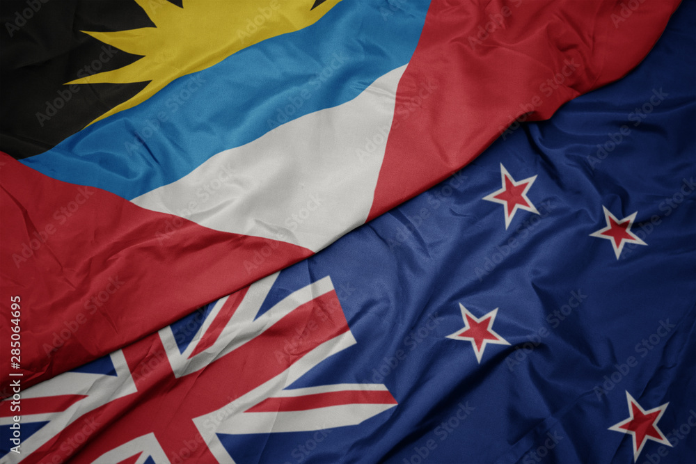 waving colorful flag of new zealand and national flag of antigua and barbuda. waving colorful flag of new zealand and national flag of antigua and barbuda.